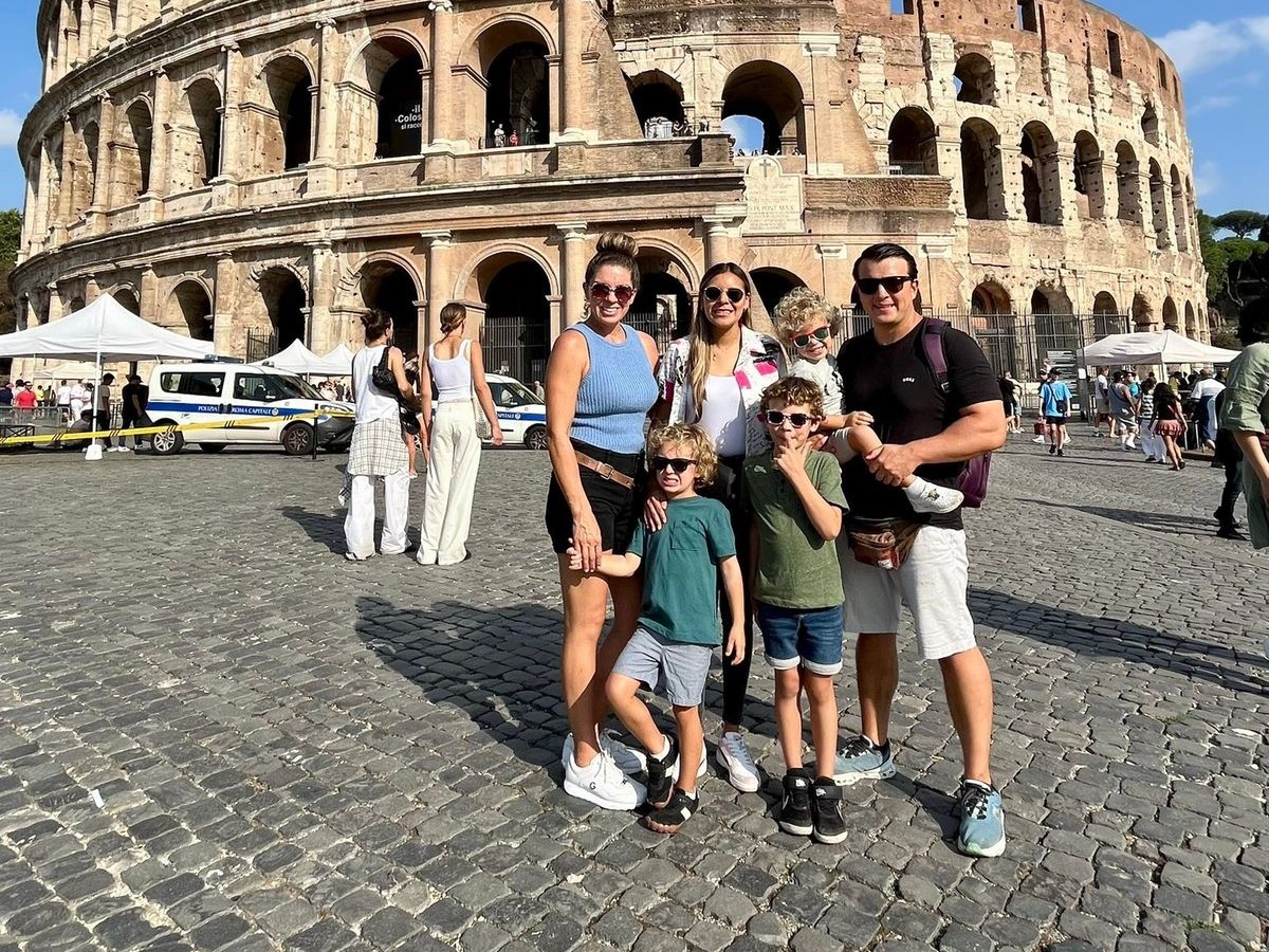 Familia de seis personas posando frente al Coliseo de Roma durante el viaje de inmersión