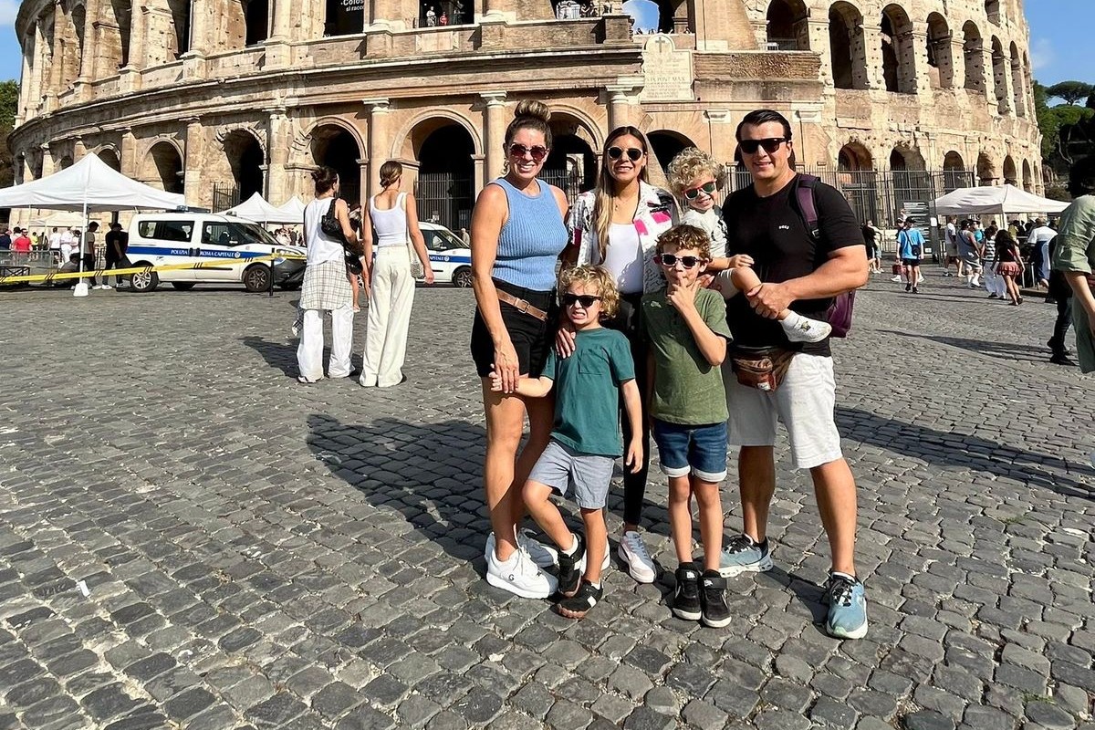 Familia de seis personas posando frente al Coliseo de Roma durante el viaje de inmersión