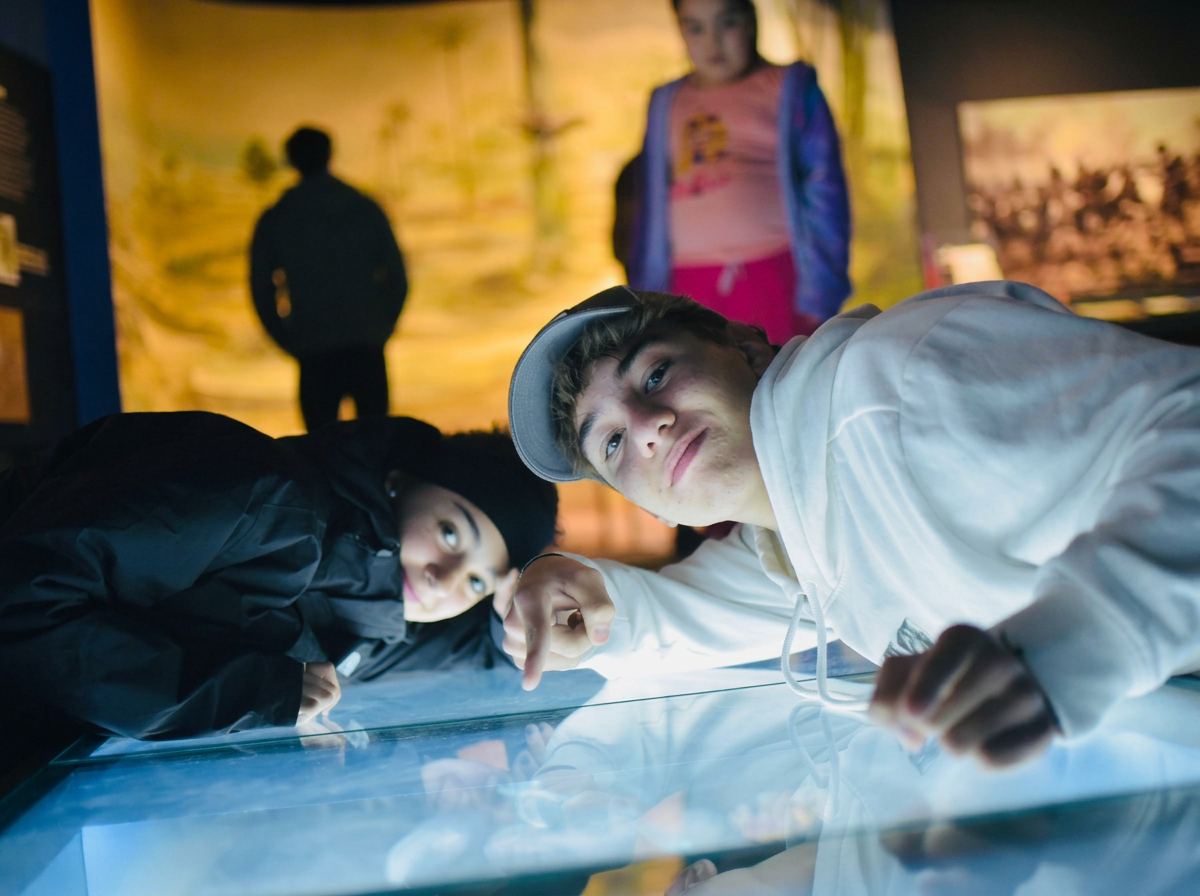 Alumnos interactuando con una exhibición iluminada en un museo de Buenos Aires