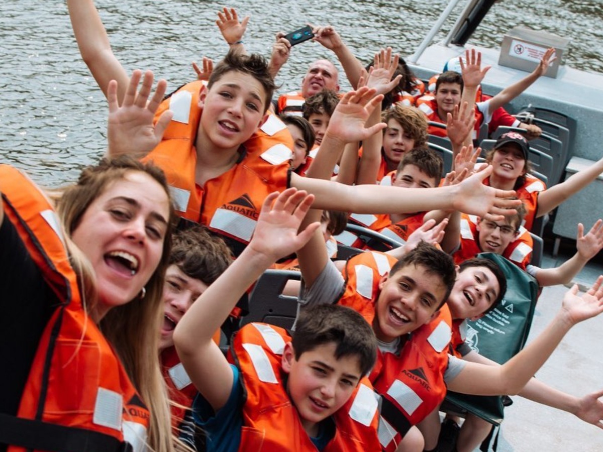 Grupo de alumnos con chalecos naranjas durante una excursión en embarcación
